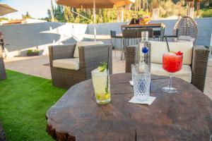 a wooden table with two drinks on top of it at Villa Kouros in Melíssia