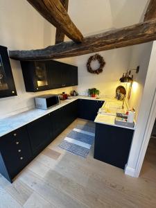 a kitchen with black cabinets and white counter tops at The stables at the Grange in York