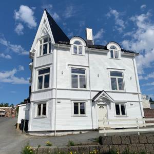een wit huis met een zwart dak bij Enter Tromsø Ultimate Luxury - Jacuzzi & Sauna in Tromsø