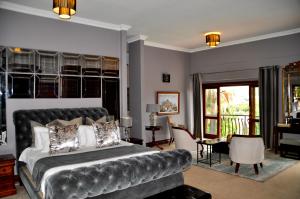 ein Schlafzimmer mit einem großen Bett und einem Balkon in der Unterkunft Ambonnay Terrace Guest House in Pretoria