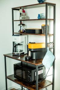 a shelf with a coffee maker and a microwave on it at Fabrikdesign Düren in Düren - Eifel