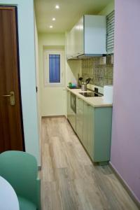 een keuken met groene kasten en een houten vloer bij H2ome Bolzaneto in Genua