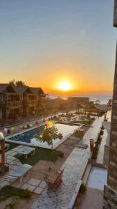 um pôr-do-sol sobre um resort com piscina em Green Beach Camp & Hotel em Nuweiba
