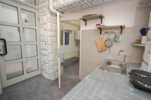 a small kitchen with a sink and a door at Studio apartman Kamenčić in Osijek +20 photos