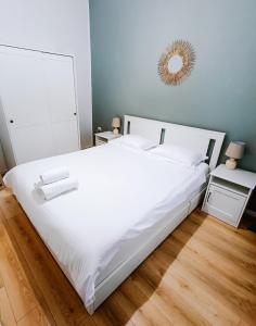 1 dormitorio con 1 cama blanca grande y espejo en Fly Residence, en Arad