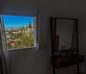 espejo en una habitación junto a una ventana en Maisonette Kavousi with Mountain and Village View, en Kavoúsion