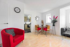 un soggiorno con tavolo e sedia rossa di 2-BR London Oasis in Woolwich a Londra