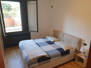 - un lit dans une chambre avec fenêtre dans l'établissement Confortevole bilocale a Basiglio - Milano 3, à Basiglio