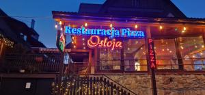 a restaurant with a neon sign on the side of a building at Willa Ostoja u Pyrca in Zakopane