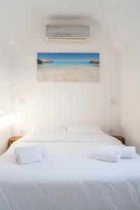 Ένα ή περισσότερα κρεβάτια σε δωμάτιο στο White House by Blue Waters Mykonos