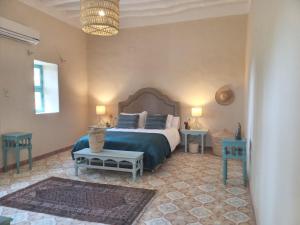 a bedroom with a bed and two tables and a chandelier at Bab Al Samawy in Luxor