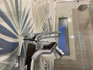 chromowana umywalka w łazience z lustrem w obiekcie Le casette di Frà Host and Go w mieście Santa Severa