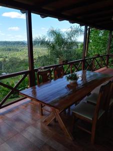 a wooden table and chairs on a porch with a view at Cabaña Las Palmeras in El Soberbio
