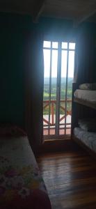 Cette chambre dispose d'un lit et d'une fenêtre avec vue. dans l'établissement Cabaña Las Palmeras, à El Soberbio