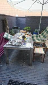 una mesa en un patio con sillas y sombrilla en Almere Centre half an hour train to Amsterdam en Almere