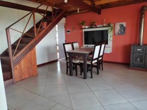 une salle à manger avec une table, des chaises et un escalier dans l'établissement Cabaña Las Palmeras, à El Soberbio