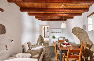 un soggiorno con divano e tavolo di White River Cottages - rustic minimalist holiday houses a Makris Gialos