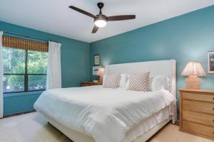 a bedroom with a white bed and a ceiling fan at Luxury StillWaters Lake Martin Townhouse in Dadeville