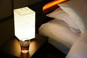 eine Lampe auf einem Tisch neben einem Glas Whiskey in der Unterkunft push house 伊東 in Ito