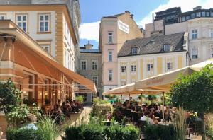 a group of people sitting at tables in a city street at LINZ CITY CENTER - Historisches Apartment & Refugium in Linz
