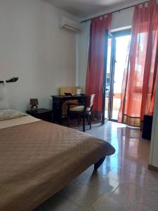 - une chambre avec un lit, une table et des chaises dans l'établissement B&B Acchiappasogni, à Corigliano dʼOtranto