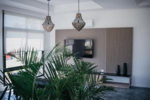 a living room with two pendant lights and a plant at Vento Hotel in María Grande
