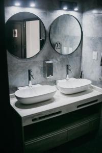 a bathroom with two sinks and two mirrors at Vento Hotel in María Grande