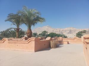 a view of a desert with palm trees and mountains at Bab Al Samawy in Luxor