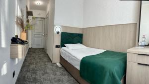 a bedroom with a bed with a green headboard at Prykarpattya in Ivano-Frankivsk