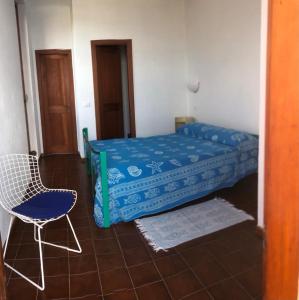 um quarto com uma cama e uma cadeira em Villa su Capo Bianco em Ponza