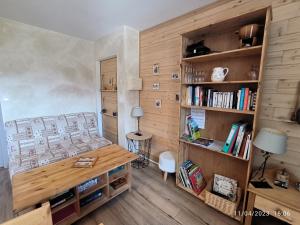 a room with a bed and a desk and bookshelves at Le petit coin au bord du lac in Doussard