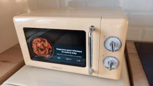 a toaster oven with a picture of a pizza inside at Amos Apartment in Košice