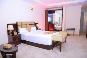 sypialnia z dużym białym łóżkiem i krzesłem w obiekcie Sunland International Hotel w Addis Abebie