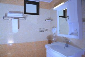 a bathroom with a sink and a toilet and a mirror at Sunland International Hotel in Addis Ababa