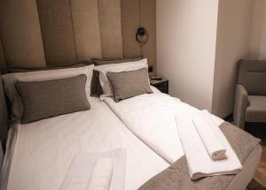 瓦列沃的住宿－Sunshine apartments - Valjevo，一张大白色的床,位于带椅子的房间