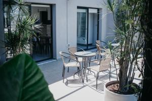 een patio met een tafel, stoelen en planten bij Vento Hotel in María Grande