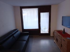 un soggiorno con divano e finestra di Petite Maison Larice a Pila