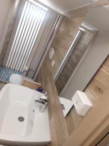 ein Badezimmer mit einem weißen Waschbecken und einem WC in der Unterkunft B&B Acchiappasogni in Corigliano dʼOtranto