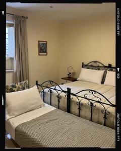 a bedroom with two beds and a table and a window at Salemi BnB in Salemi