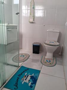 a bathroom with a toilet and a sign on the floor at Pousada Divina Fé in Aparecida
