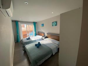 a bedroom with three beds with blue pillows on them at Camp Nou Nueva Casa in El Arrabal