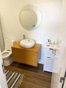 a bathroom with a sink and a toilet and a mirror at Machico center w/ terrace 5 min beach in Machico