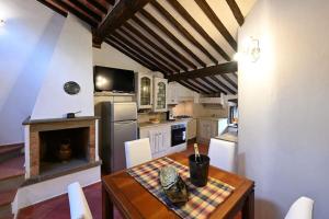 een keuken met een houten tafel en een open haard bij La casa nel borgo in Cavriglia