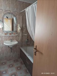 a bathroom with a sink and a bath tub and a mirror at Central Hotel in Schwetzingen