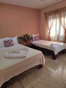 a hotel room with two beds with a heart on them at Cabinas Agamy in Tortuguero