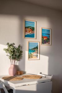 a white table with three pictures on the wall at Studio vue mer climatisé à 100m des plages in Saint-Jean-Cap-Ferrat