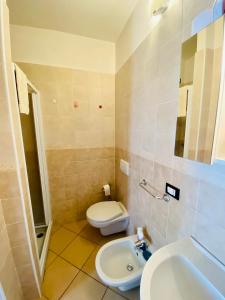 La salle de bains est pourvue de toilettes blanches et d'un lavabo. dans l'établissement Casa Giuliana, à Teglio