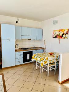 a kitchen with a table and a white refrigerator at Casa Giuliana in Teglio