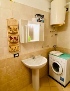 a bathroom with a sink and a washing machine at Casa Giuliana in Teglio