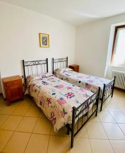 1 Schlafzimmer mit 2 Betten, einem Tisch und einem Fenster in der Unterkunft Casa Giuliana in Teglio